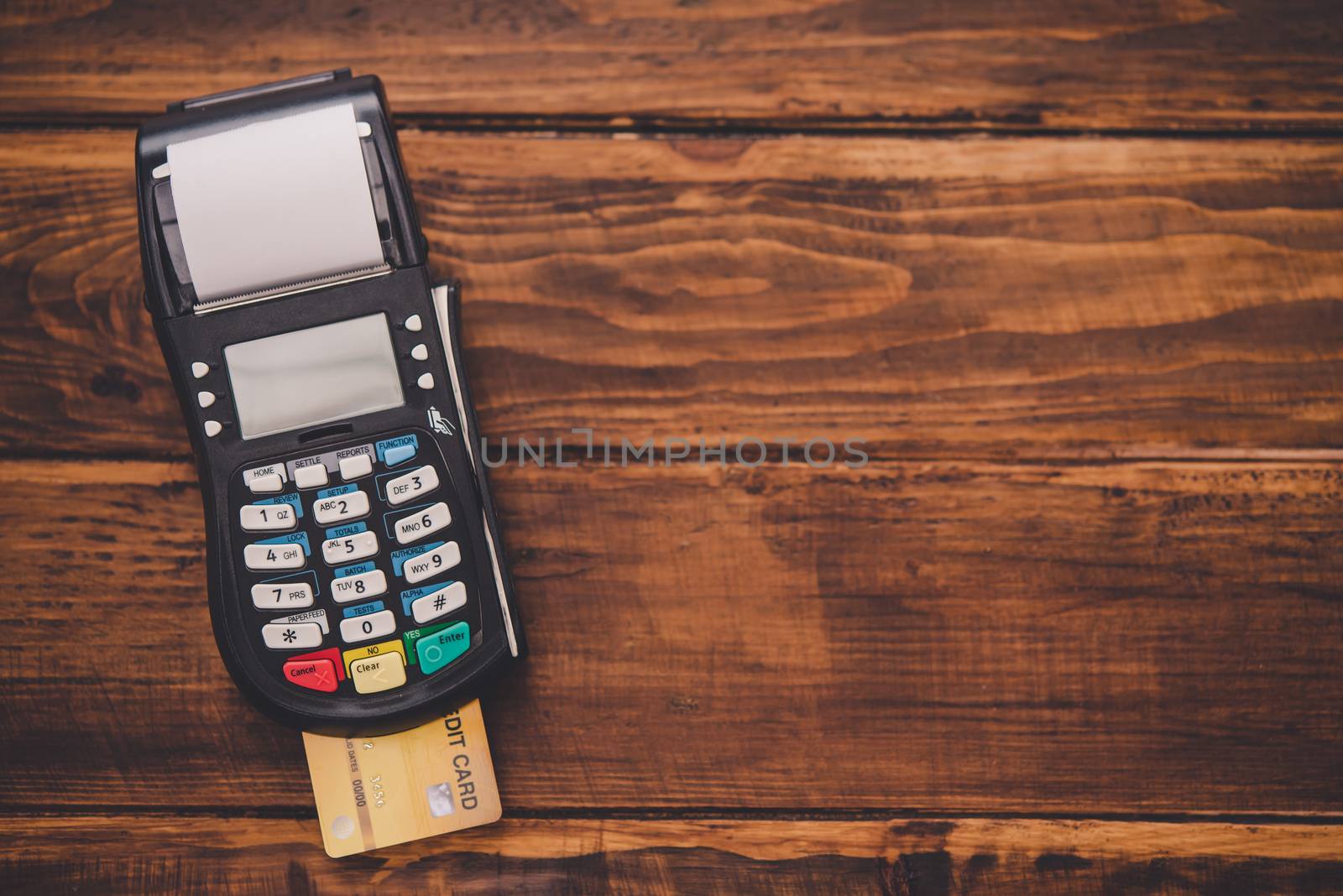  Top view credit card swipe machine placed on a wooden floor , M by photobyphotoboy