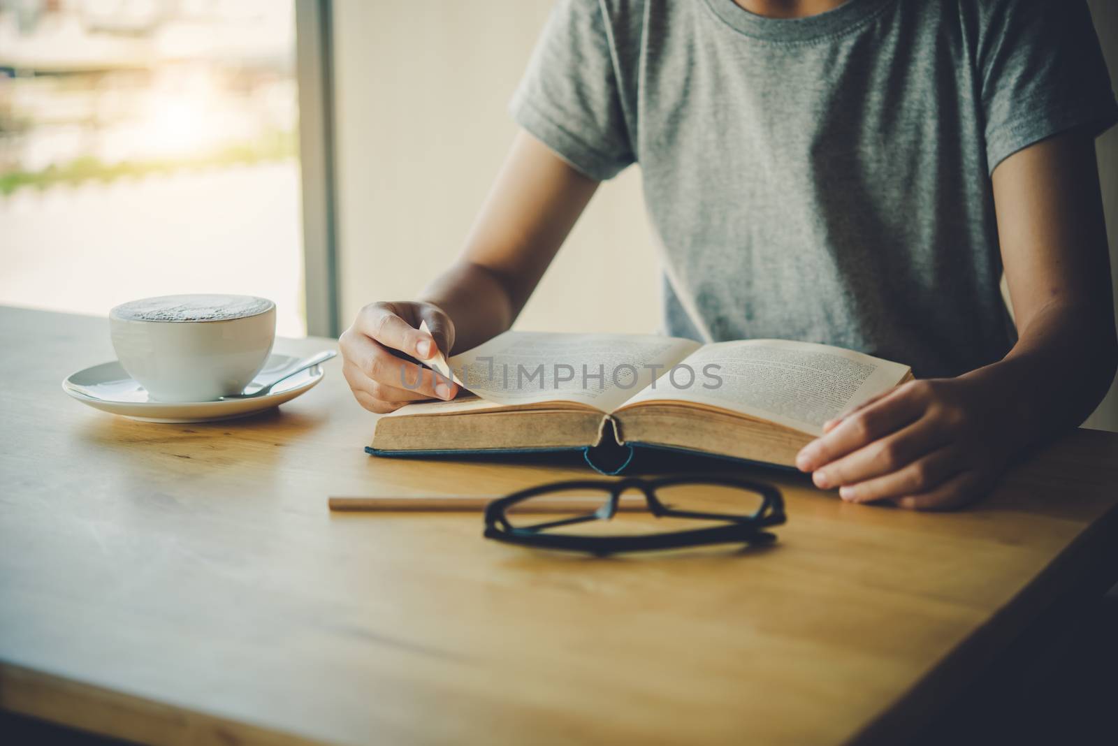 woman sitting in a room reading a book by photobyphotoboy