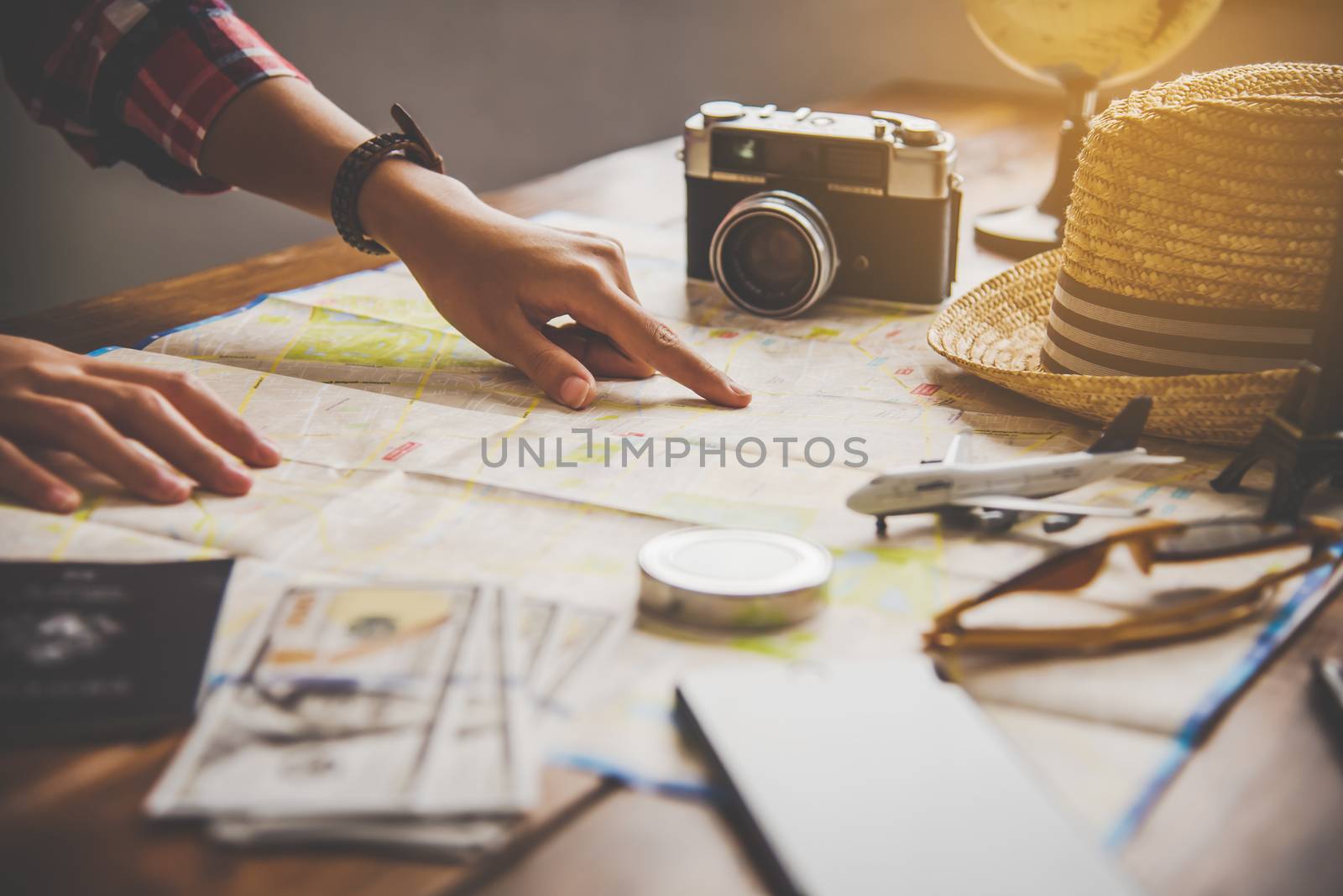 Travelers are planning a trip by searching the route on the map  by photobyphotoboy