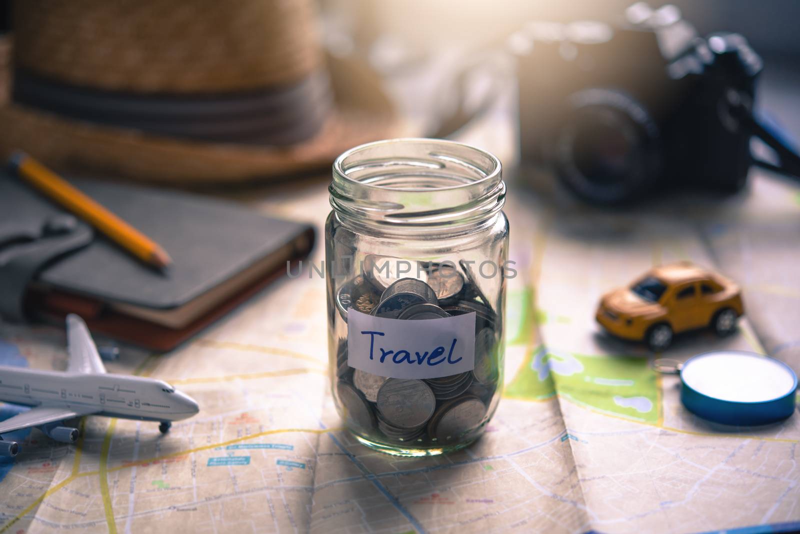 The money in the jar stored on the map, along with a passport, concept to collect money for travel.