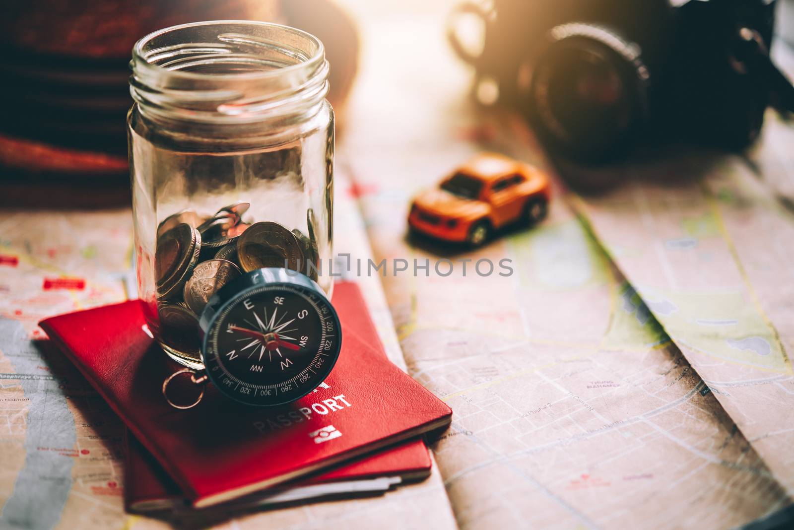 The money in the jar stored on the map, along with a passport, concept to collect money for travel.