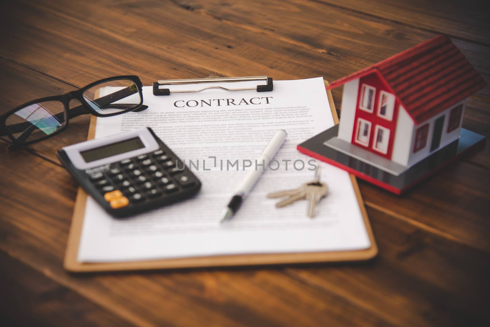 Model of house placed on contract Placed on a wooden table, mort by photobyphotoboy