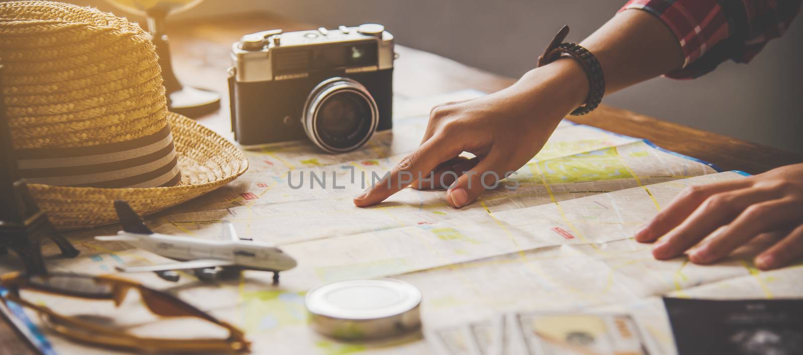 Travelers are planning a trip by searching the route on the map  by photobyphotoboy