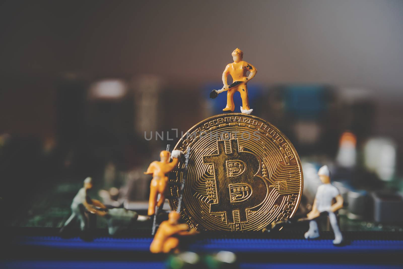 Miniature people or small figure worker on  gold bitcoin.  Bit c by photobyphotoboy