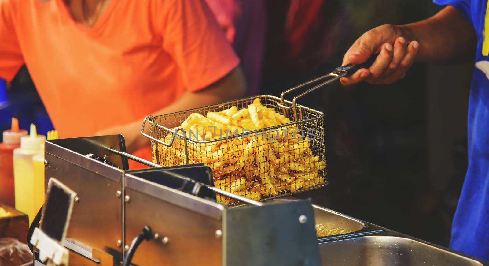 Employees frying french fries with hot oil. Selling food on the street.