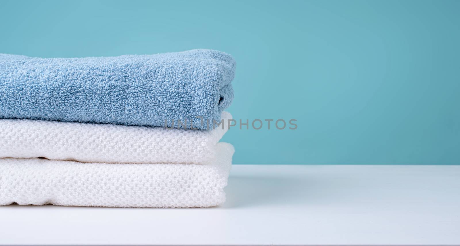 Laundry concept. Stack of clean towels on blue background