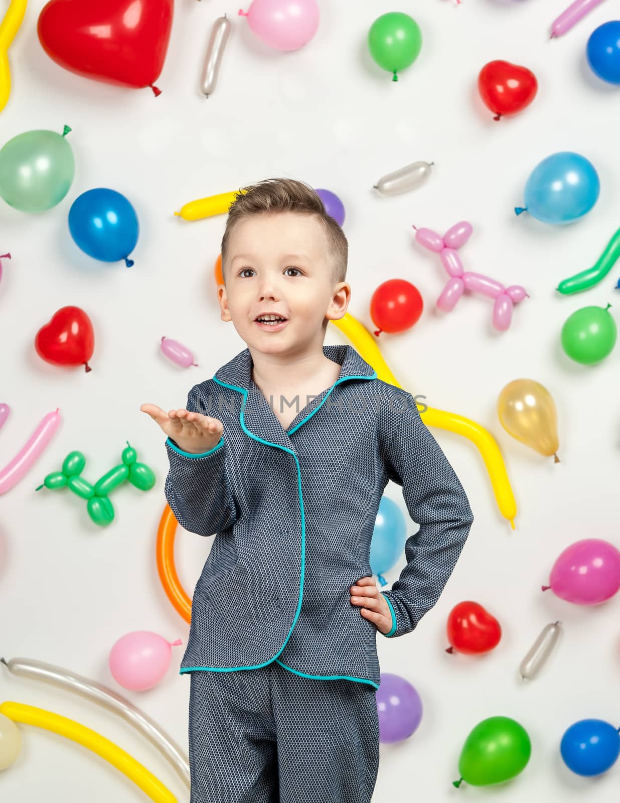 boy on a white background with colorful balloons. boy sending an air kiss on a white background with balloons in the shape of a heart