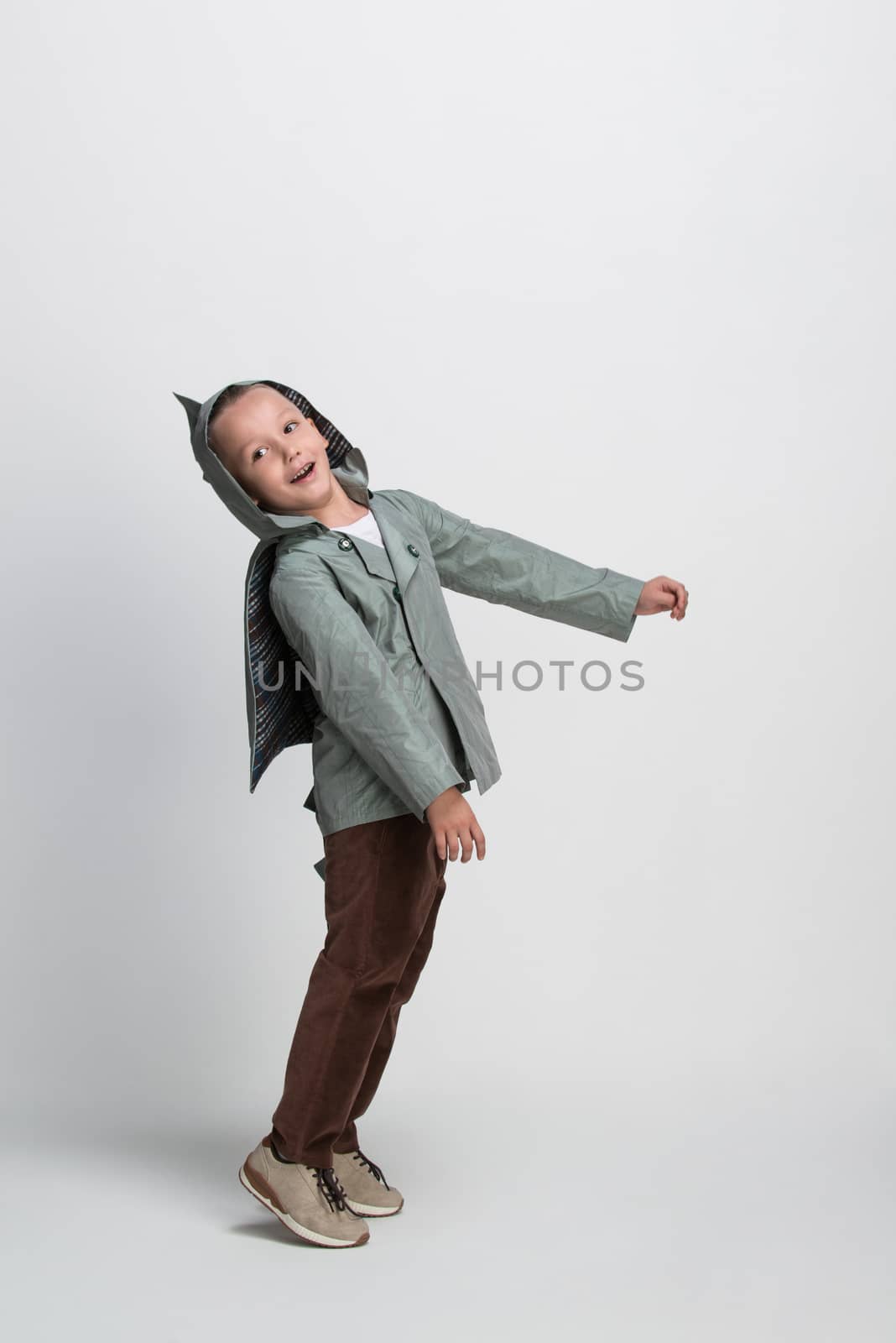 happy little boy with arms outstretched on white background, studio shooting