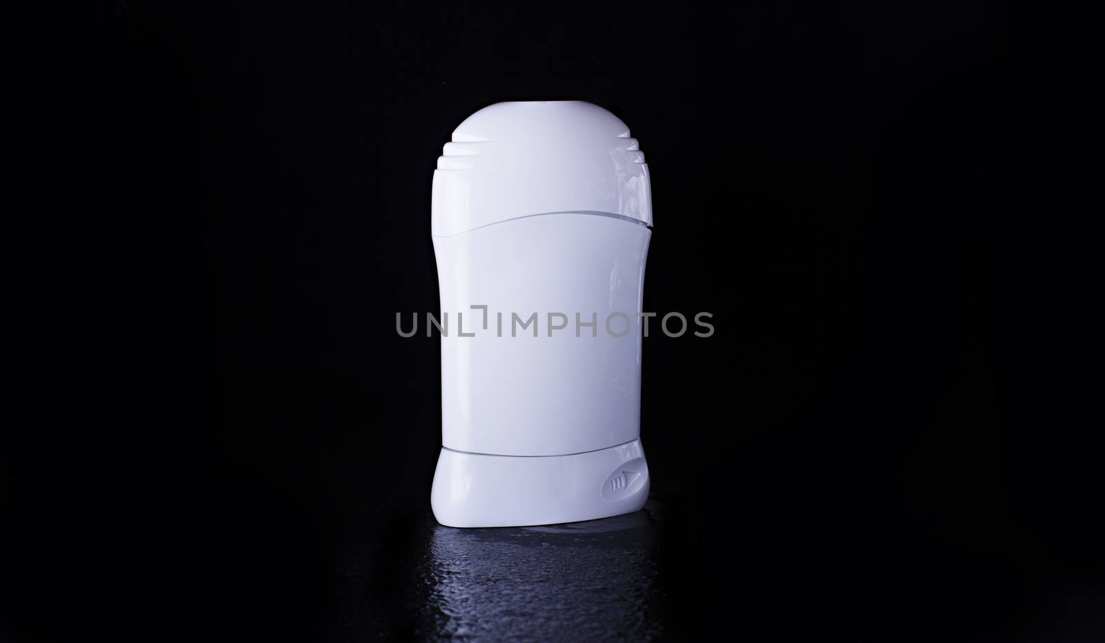Dry deodorant in a white bottle on a black background with reflection below. Advertising photo of antiperspirant. Mock up deodorant.
