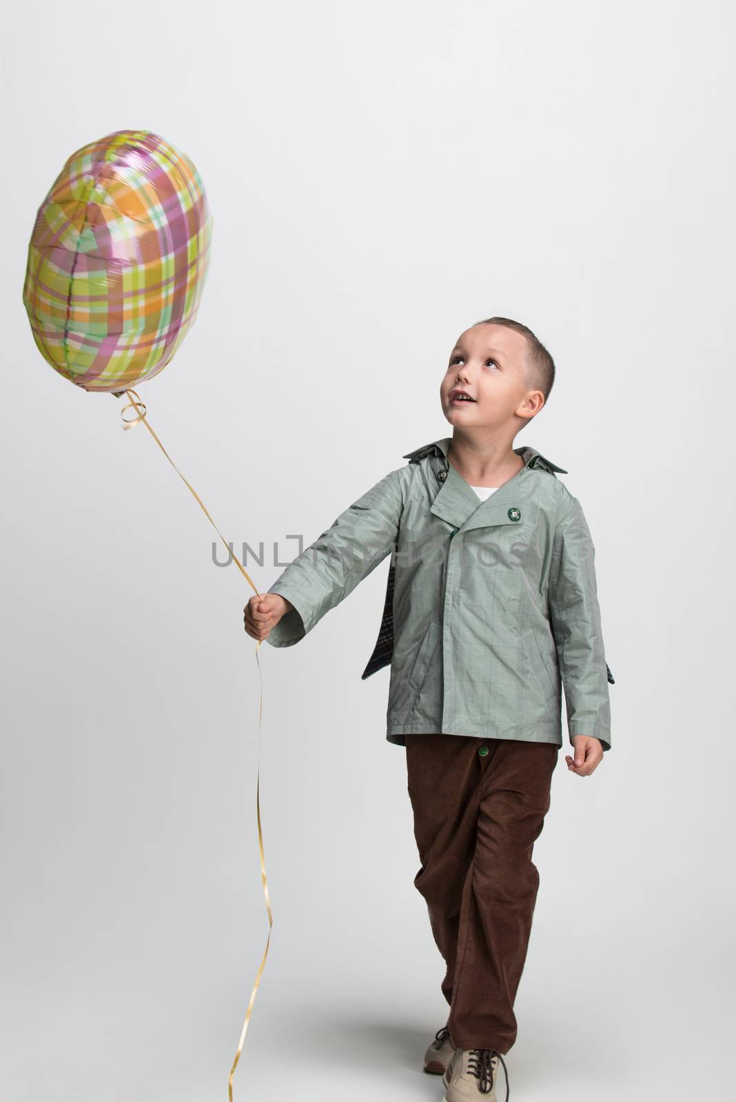 happy little boy with balloon on white background, studio shot