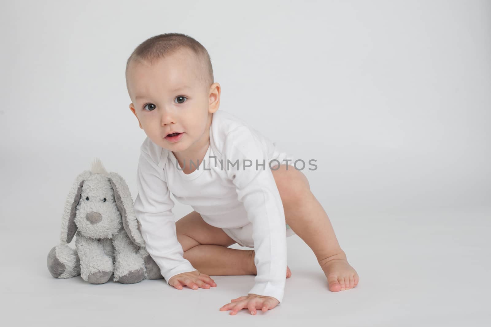 baby on a white background with a soft toy bunny