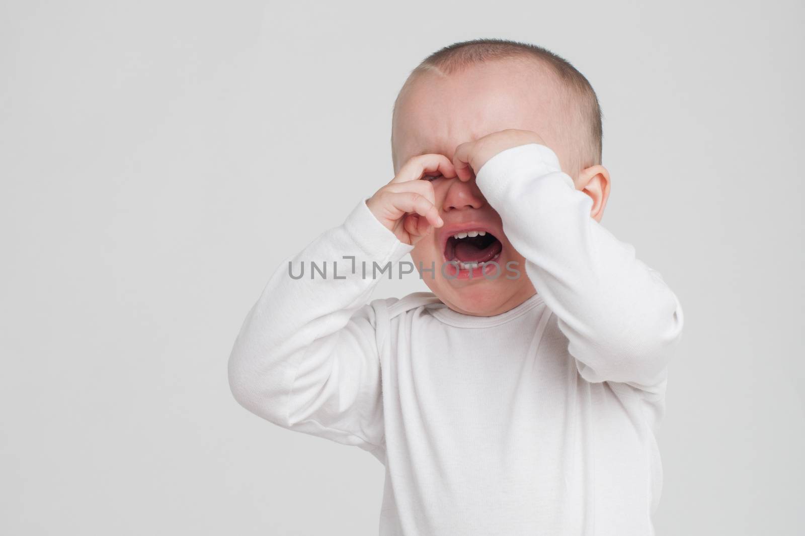 baby on a white background in a white pajamas