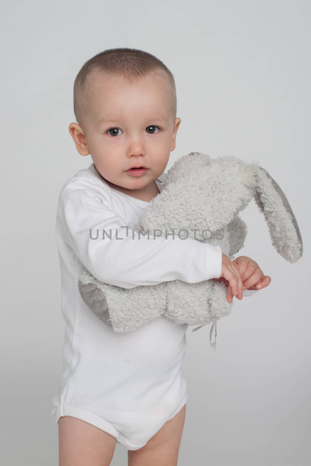 baby on a white background with a soft toy bunny