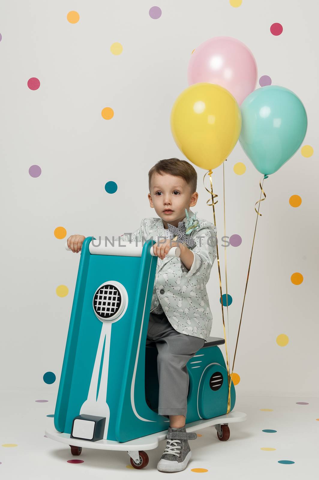 boy on a toy motorcycle on a white background by A_Karim