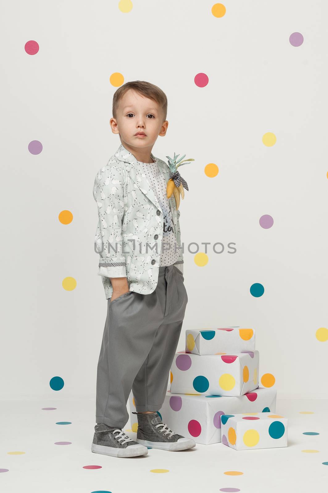 little boy in the trendy and designer suits and sneakers on a white background