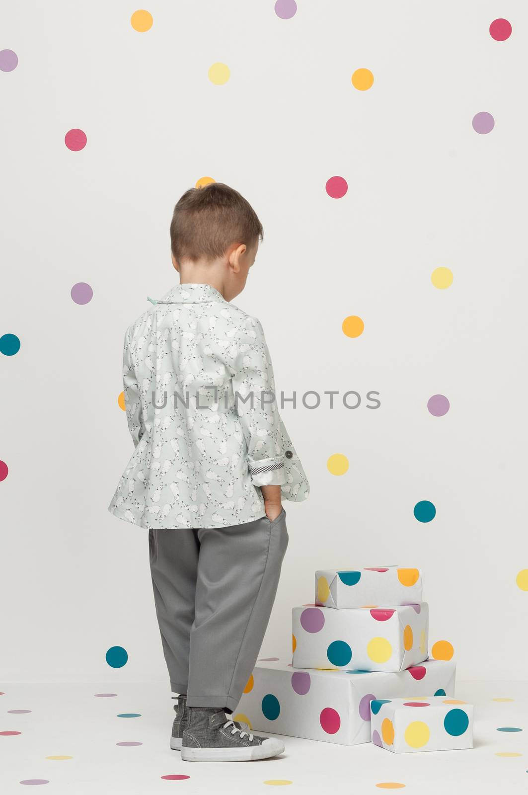 little boy in the trendy and designer suits and sneakers on a white background