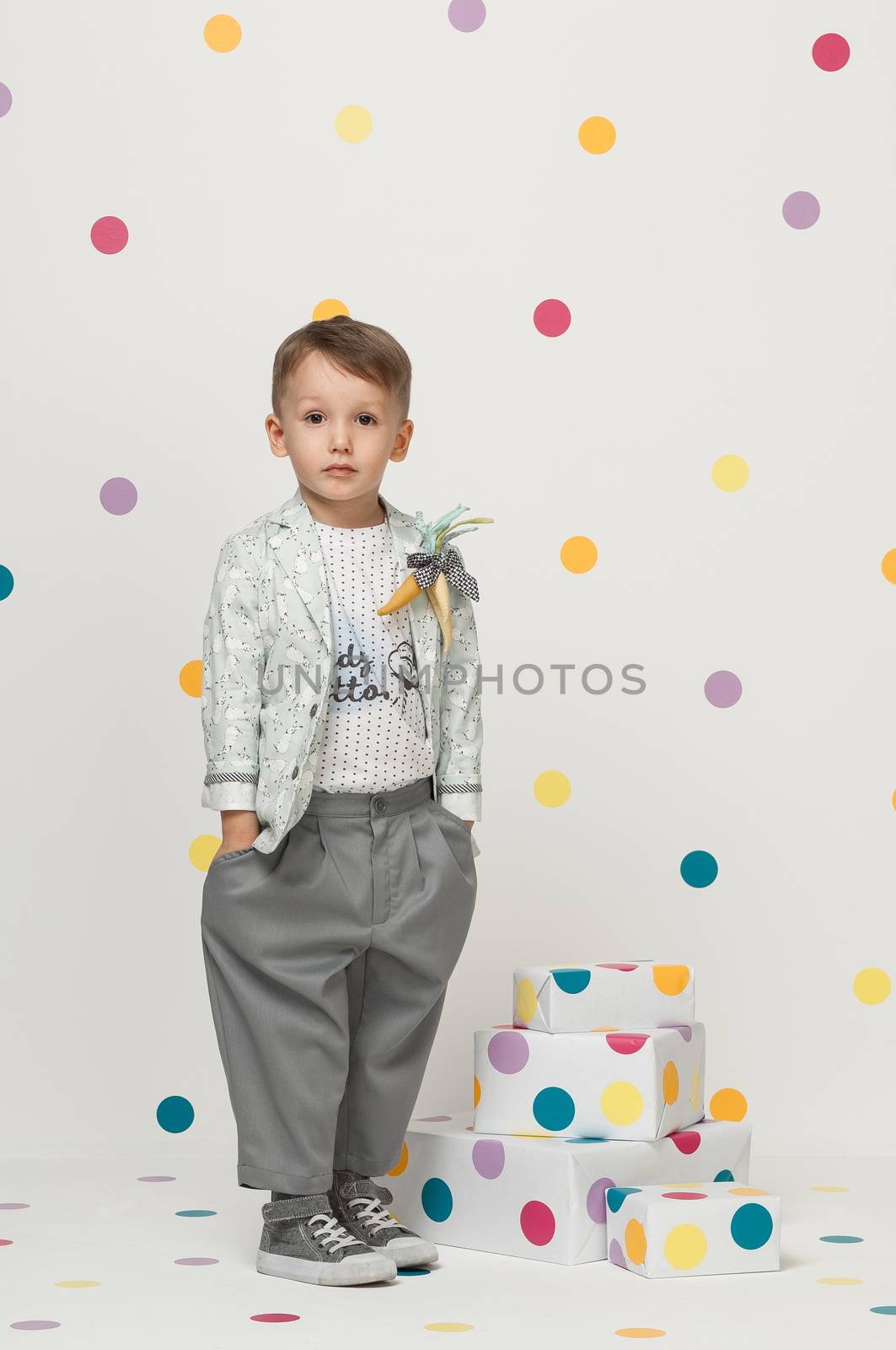 little boy in the trendy and designer suits and sneakers on a white background