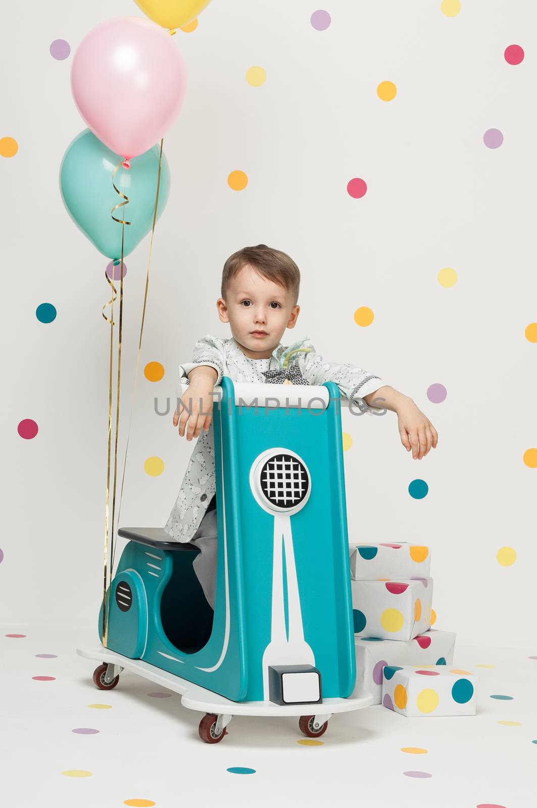 boy on a toy motorcycle on a white background by A_Karim