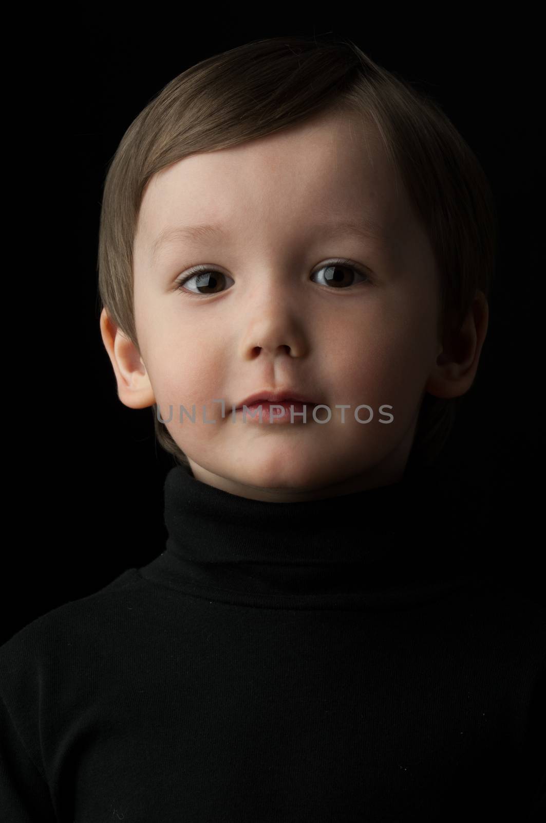 portrait of a little boy on a dark background