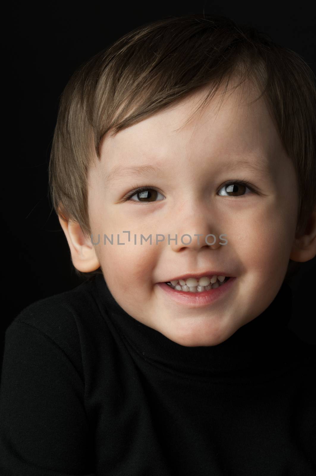 portrait of a little boy on a dark background