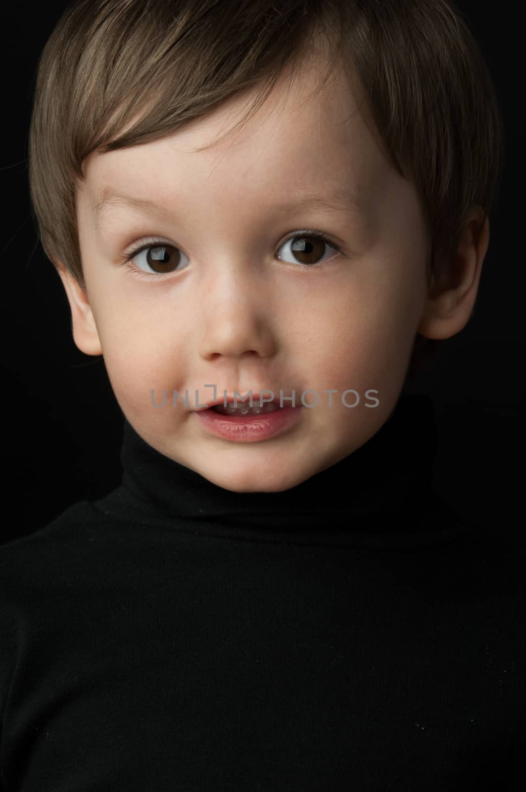portrait of a little boy on a dark background