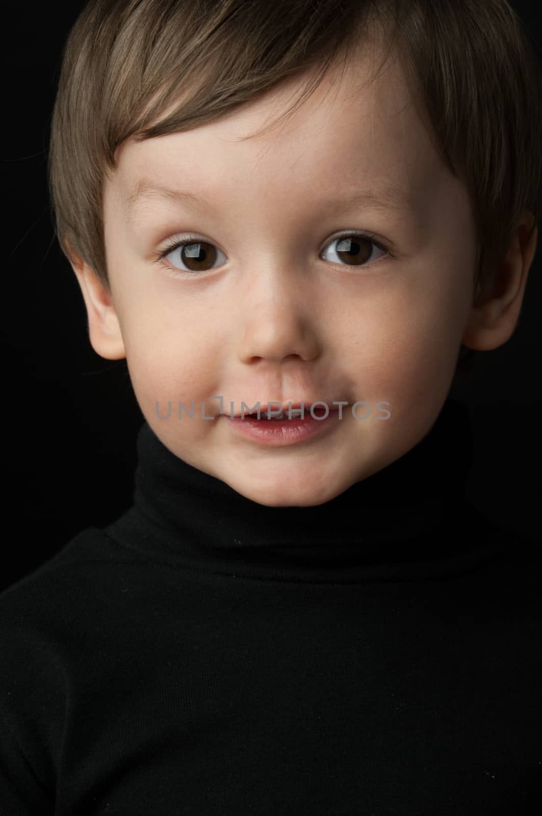 portrait of a little boy on a dark background