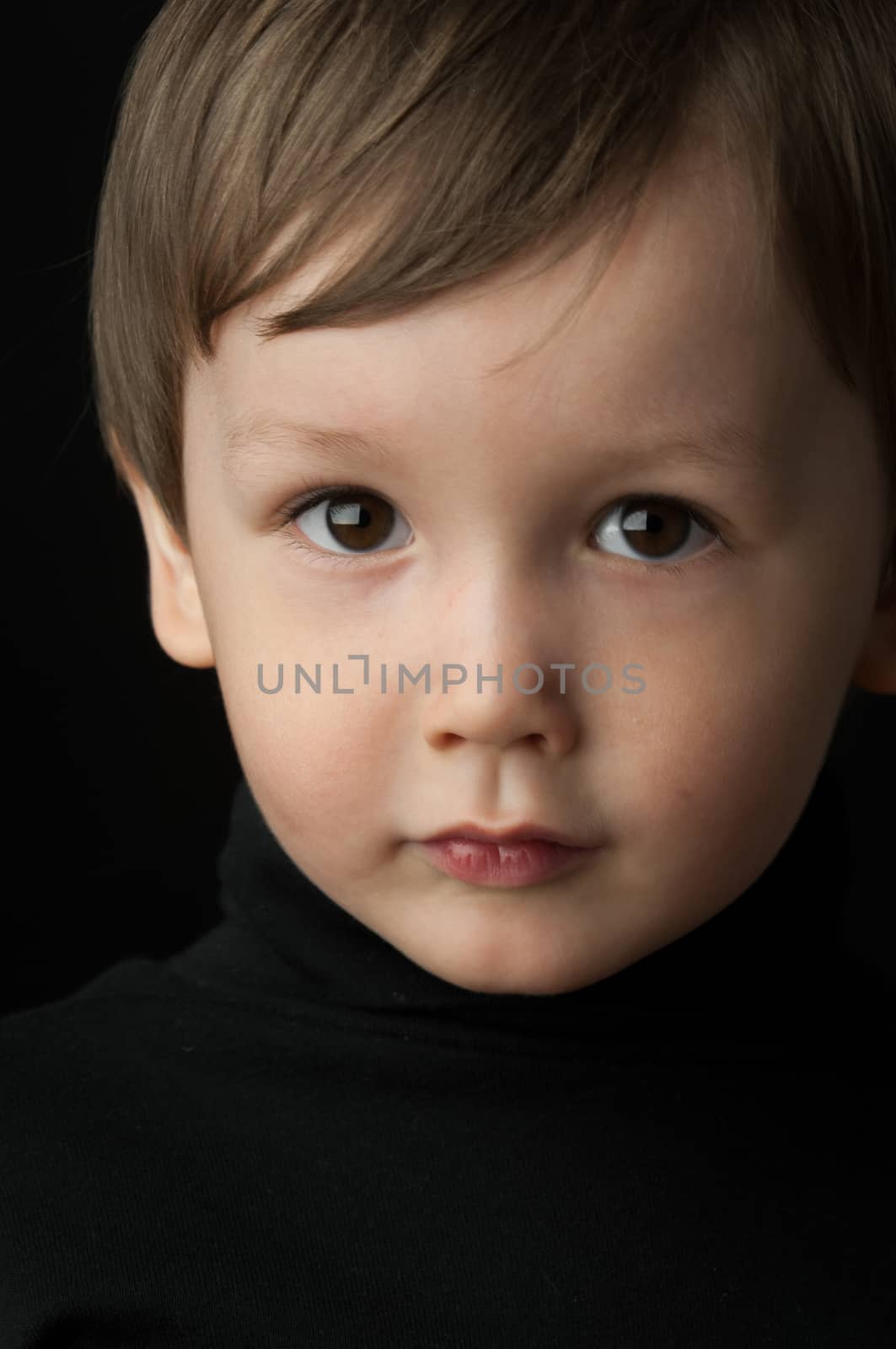 portrait of a little boy on a dark background