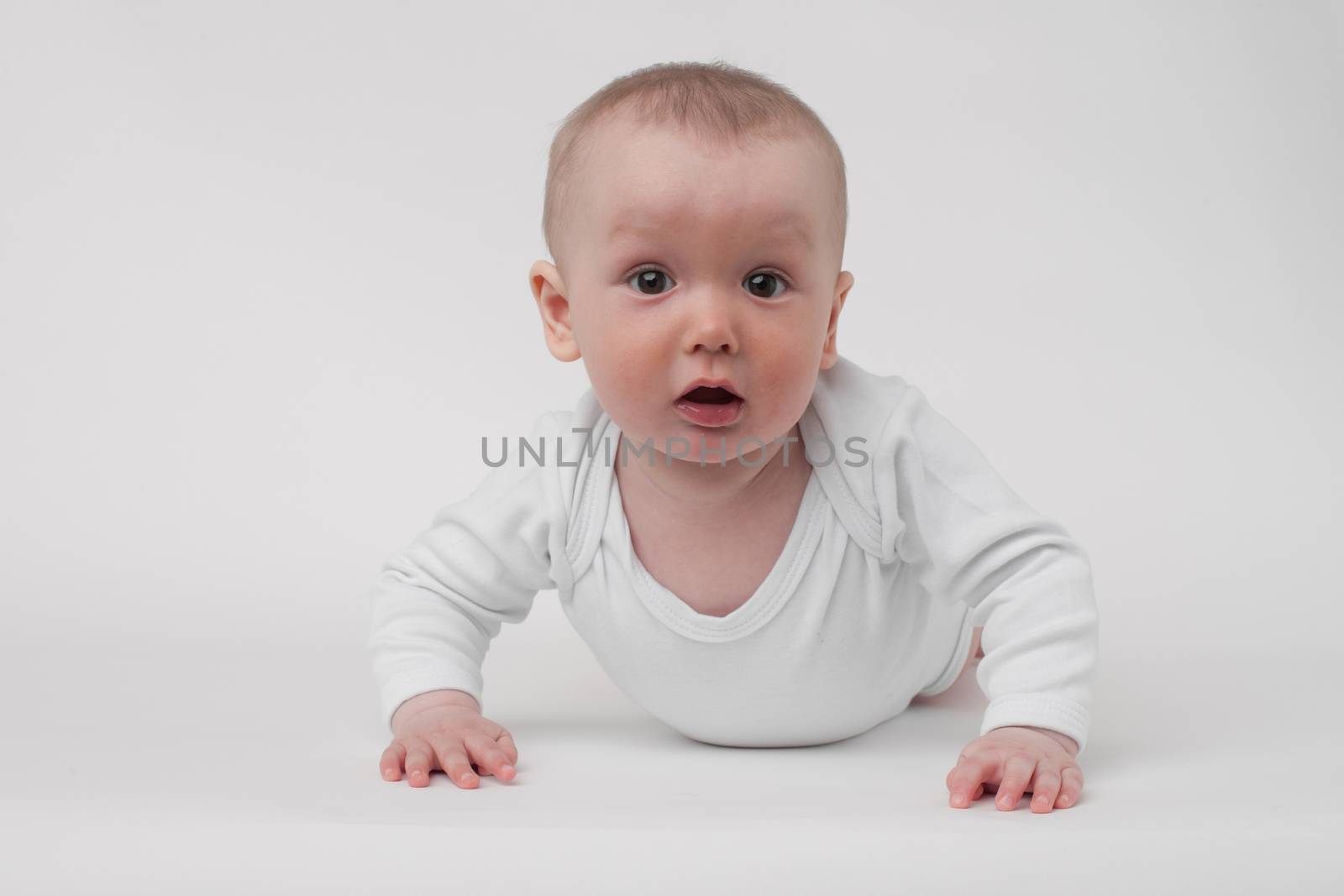 baby on a white background in a white pajamas