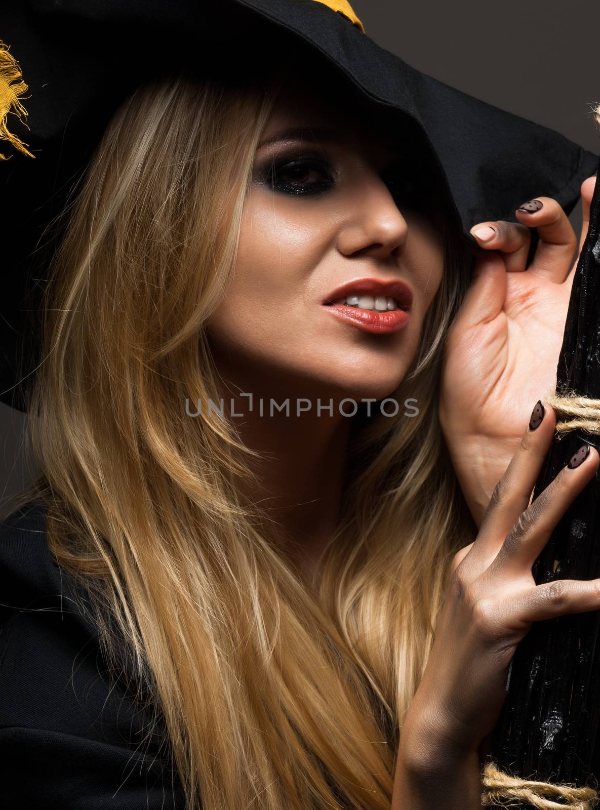 on halloween beautiful girl in a witch hat on a dark background