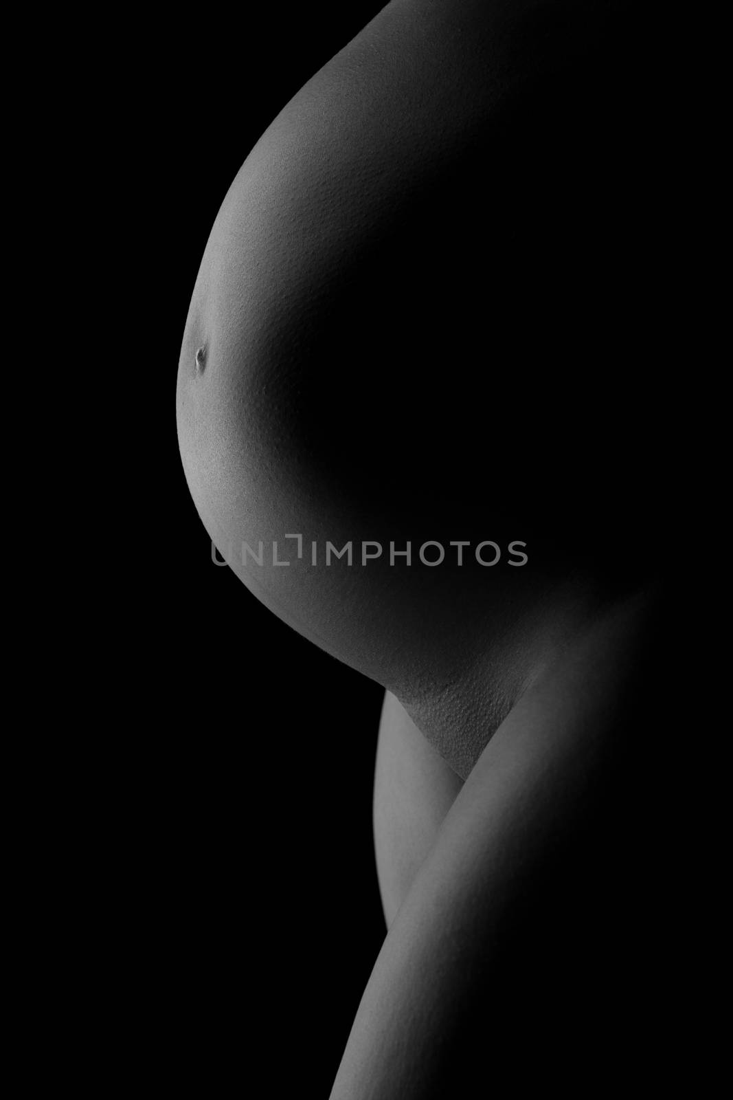 belly of a pregnant woman on a dark background by A_Karim