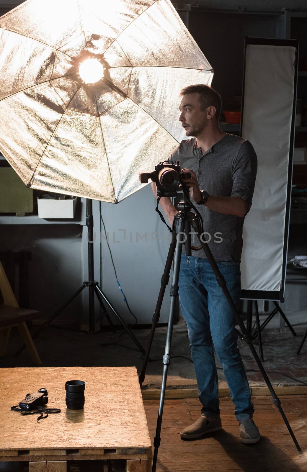 photographer with camera on a tripod in the background of the lighting equipment