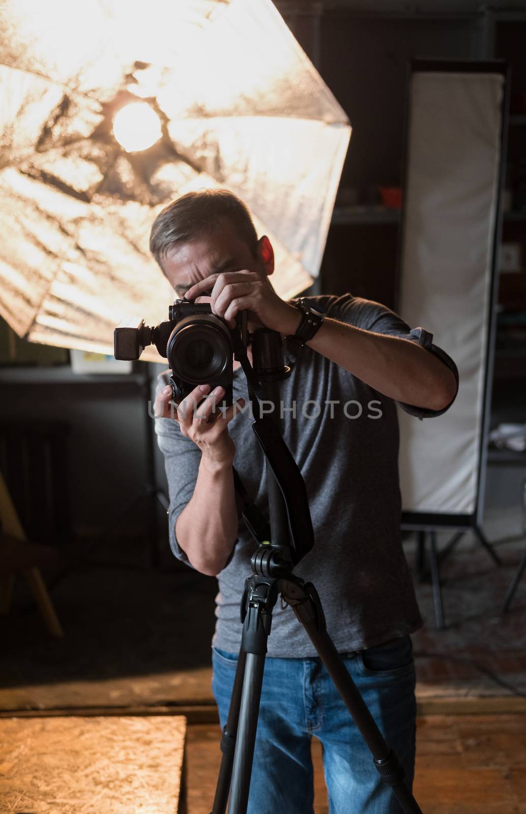 in the Studio the man in the process of photographing on the background of bright lighting equipment