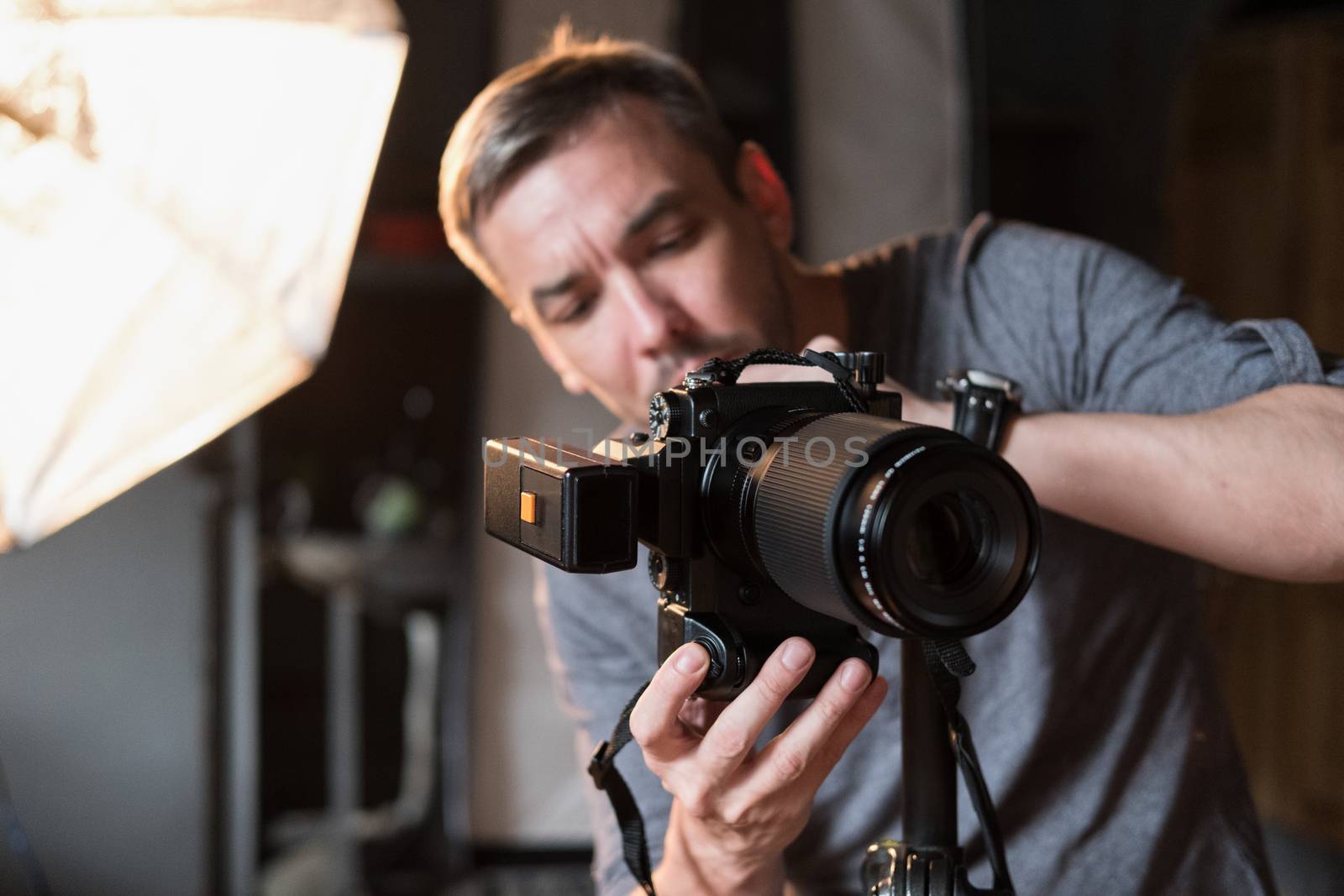 the young man adjusts the camera during photographing in the Studio