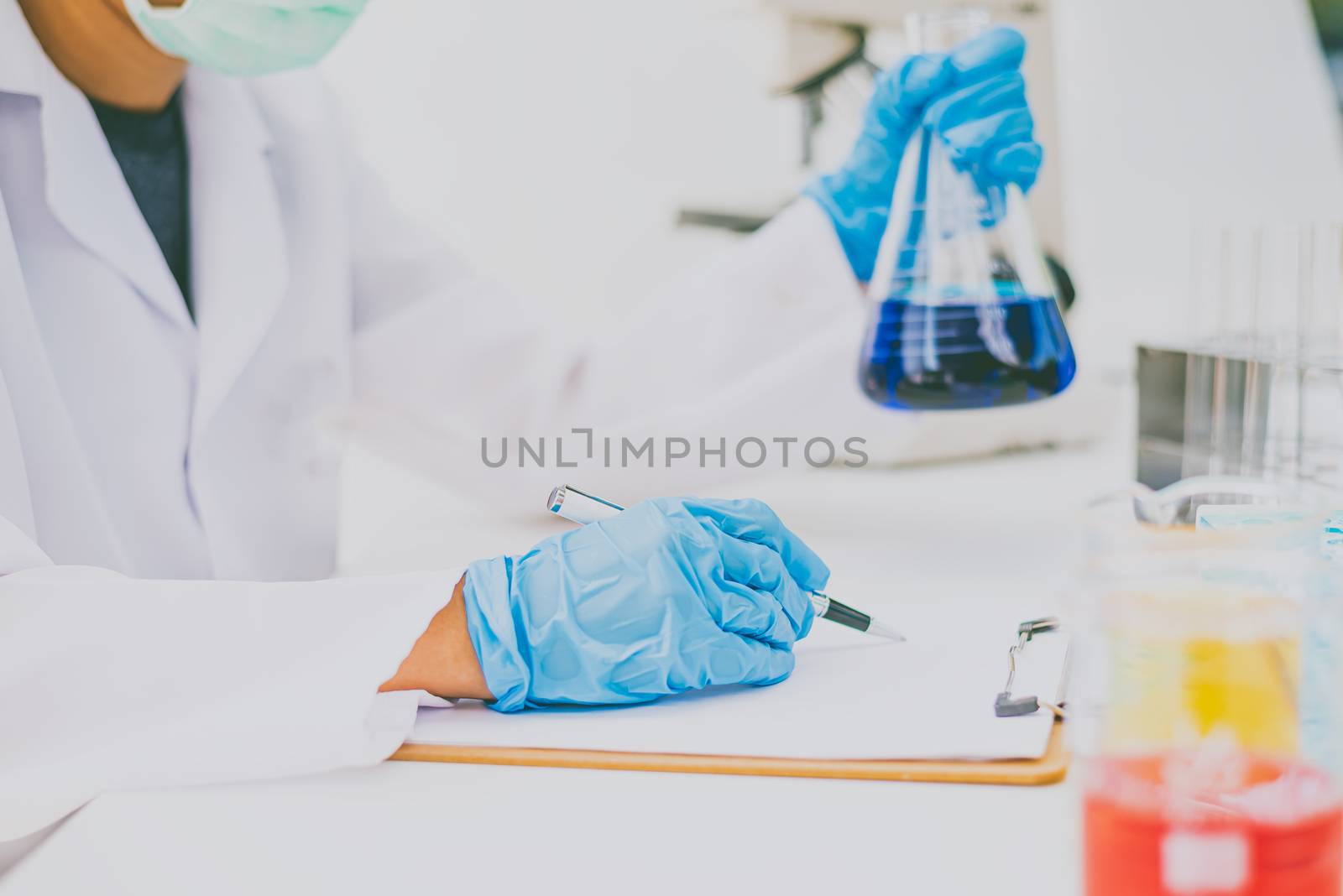  The scientist is recording the scientific value on a note. In a by photobyphotoboy