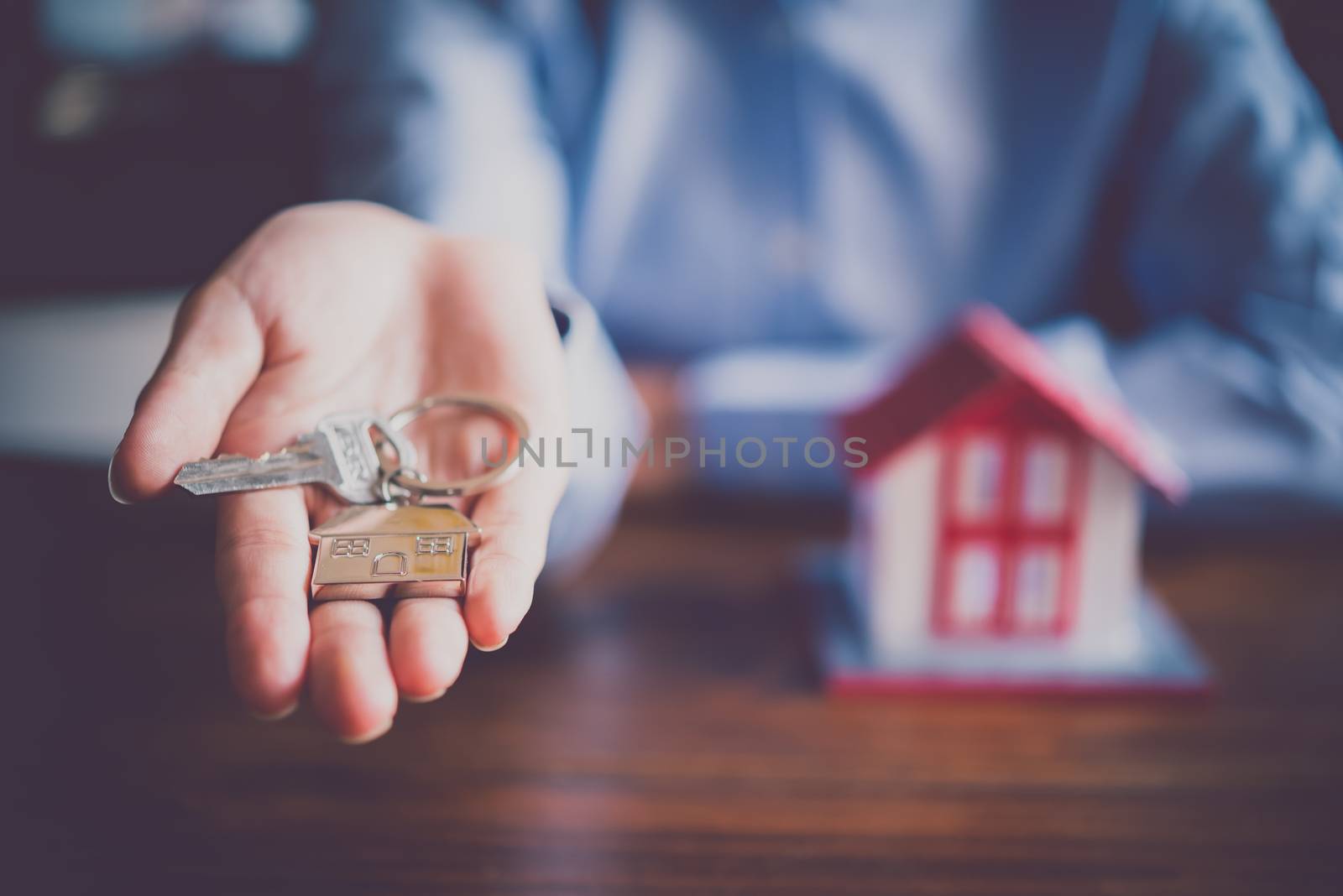 Salesperson Holding house keys concept, house keys for new house, new house purchase