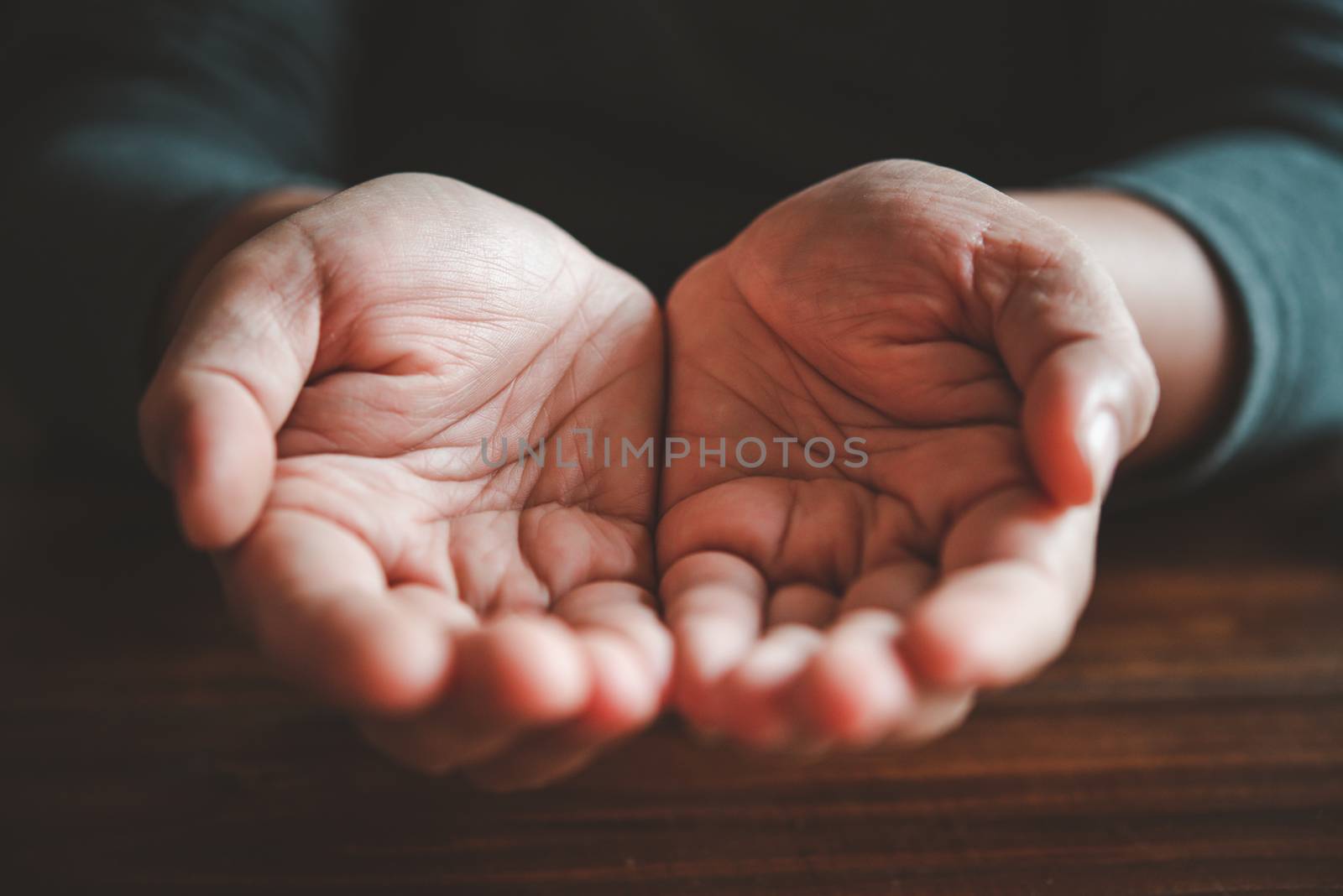 open two hands on wood background - concept help by photobyphotoboy