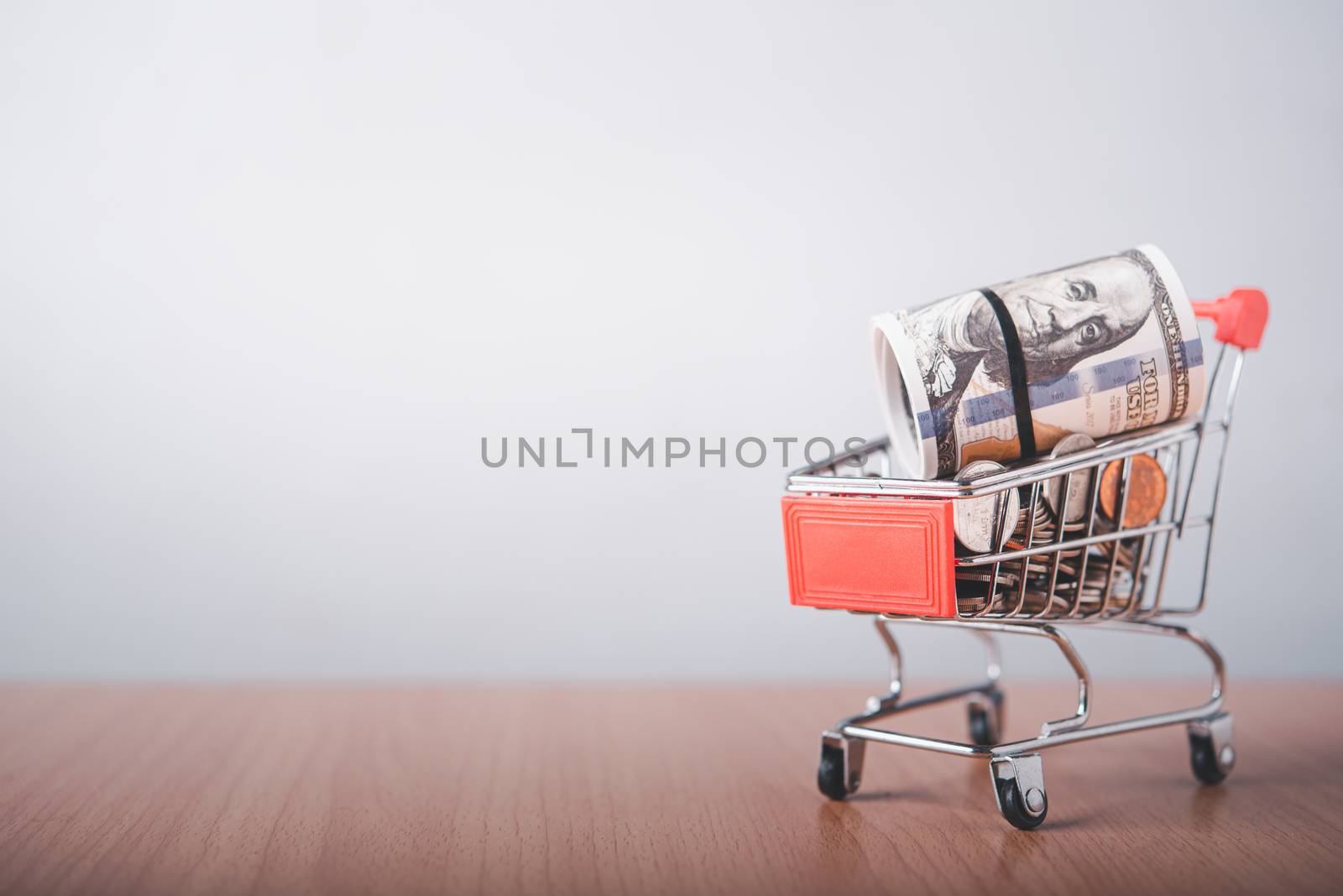  The currency coin is in a shopping cart that is placed on a wooden floor.