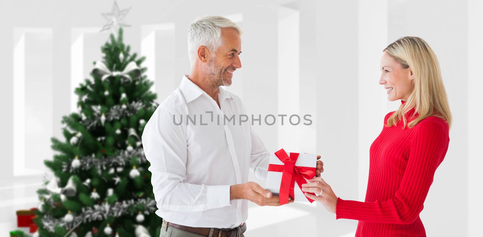 Composite image of loving couple with gift by Wavebreakmedia