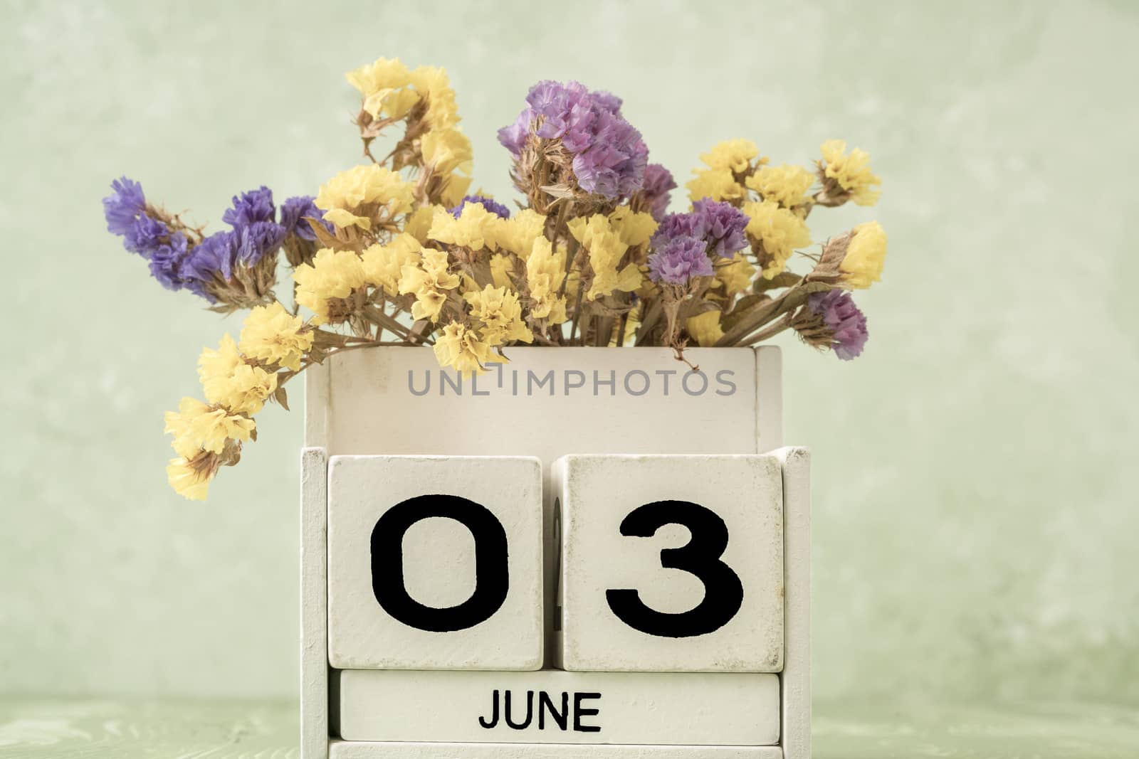 White cube calendar for june on green background with copy space by bernanamoglu