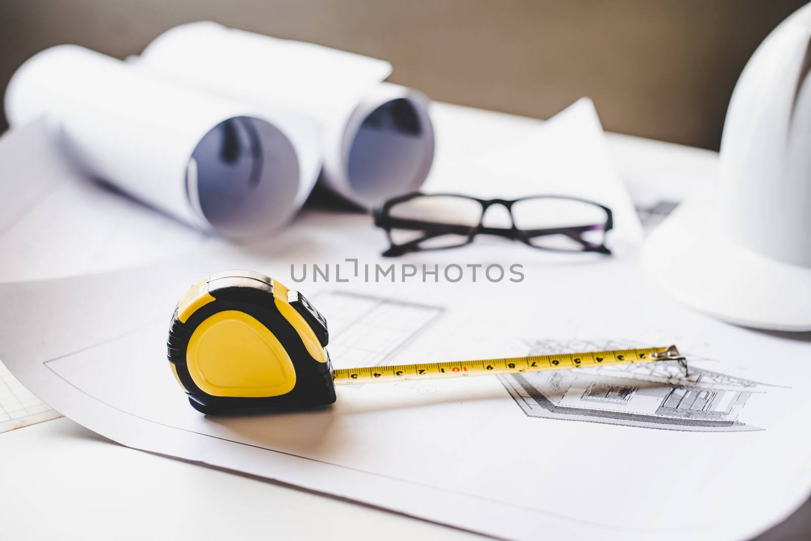  tape measure is placed on the work table with a house plan designed Including engineering equipment