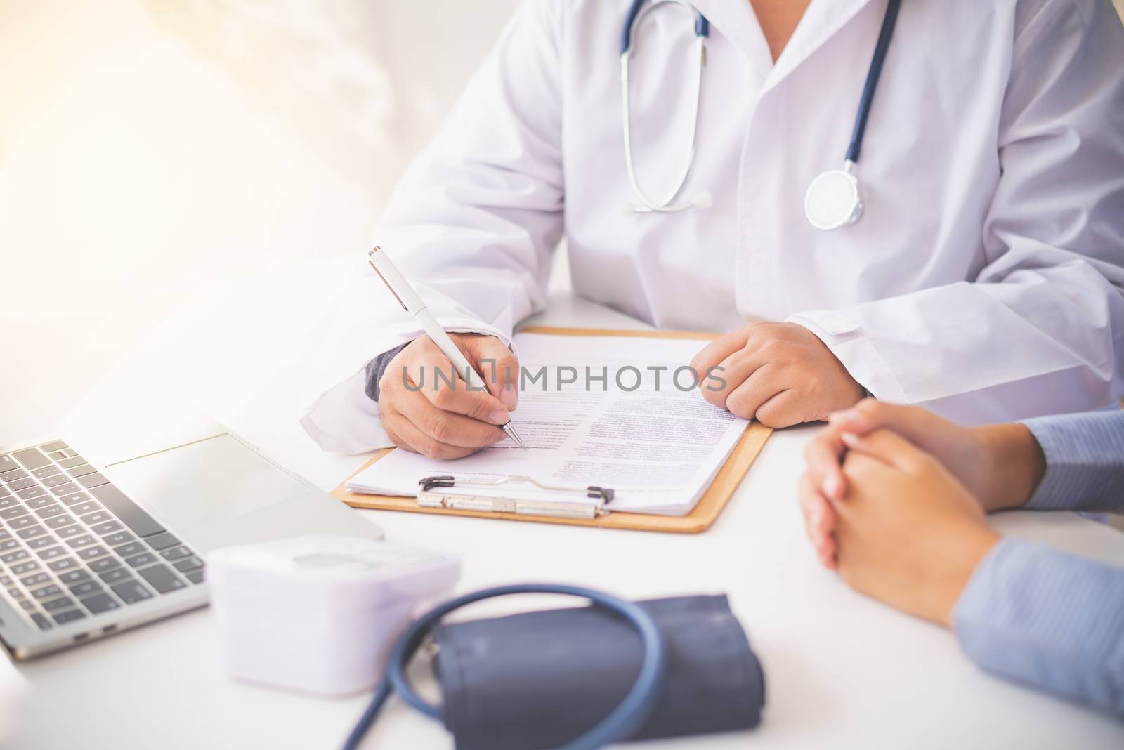 The doctor is discussing with the patient after a physical exami by photobyphotoboy