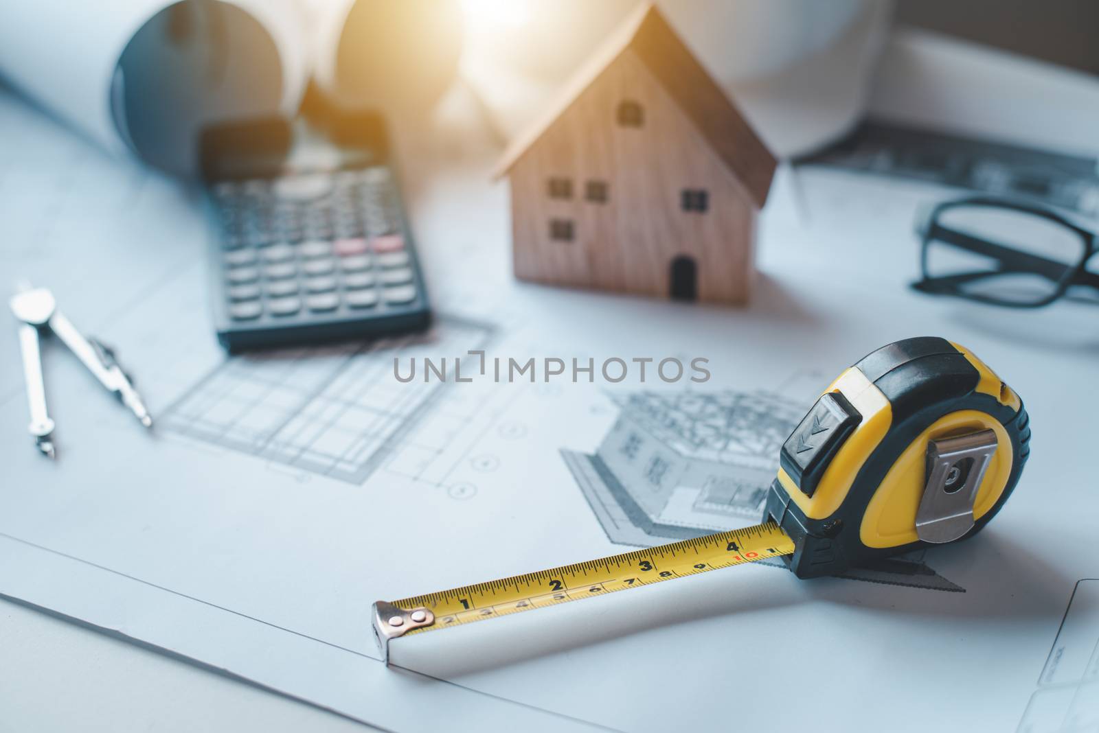  tape measure is placed on the work table with a house plan designed Including engineering equipment