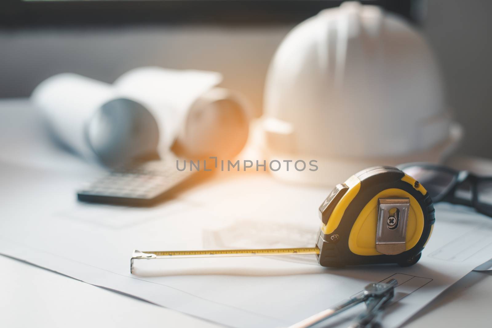  tape measure is placed on the work table with a house plan desi by photobyphotoboy