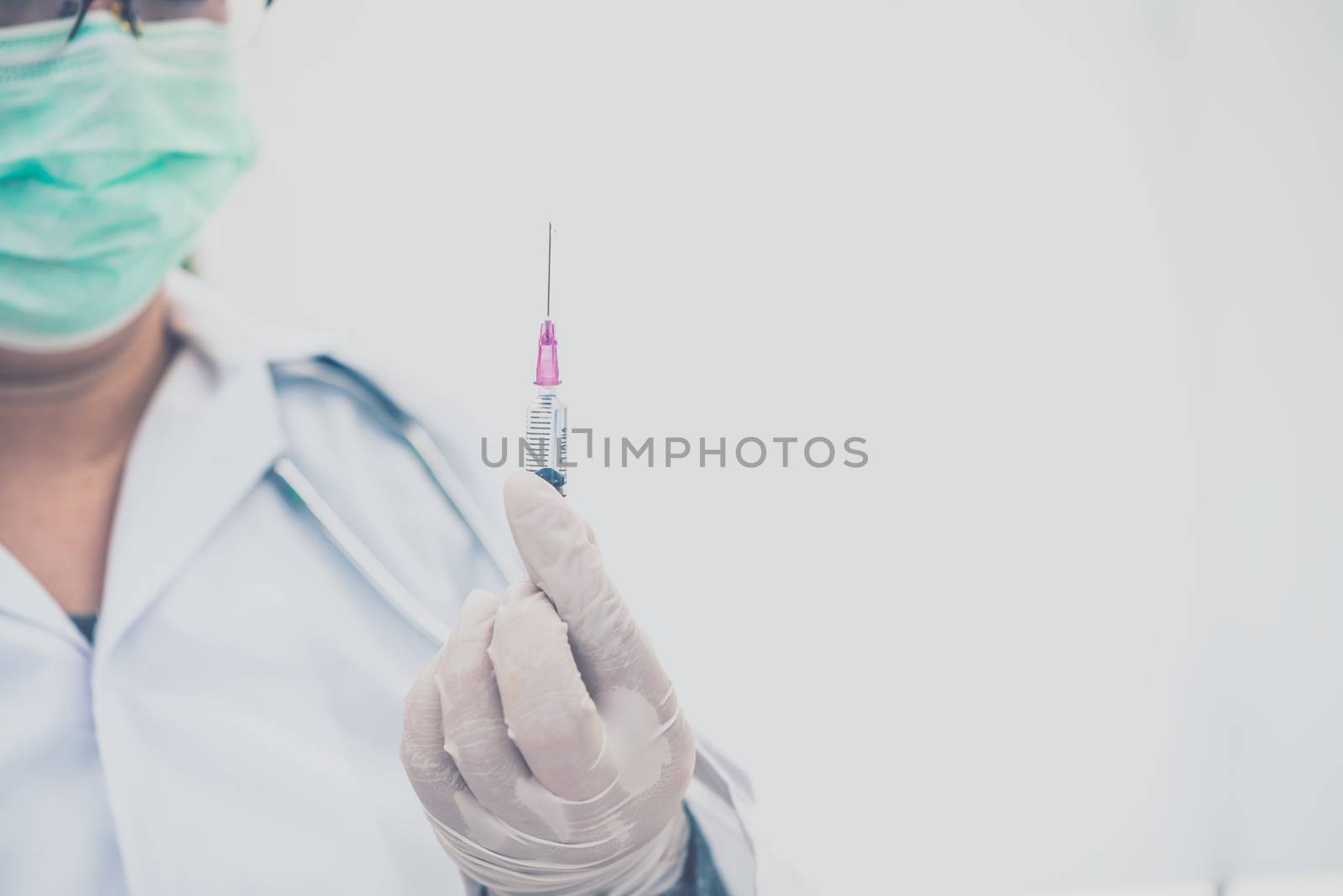 Doctor with syringe ready for injection of vaccine to patient. V by photobyphotoboy