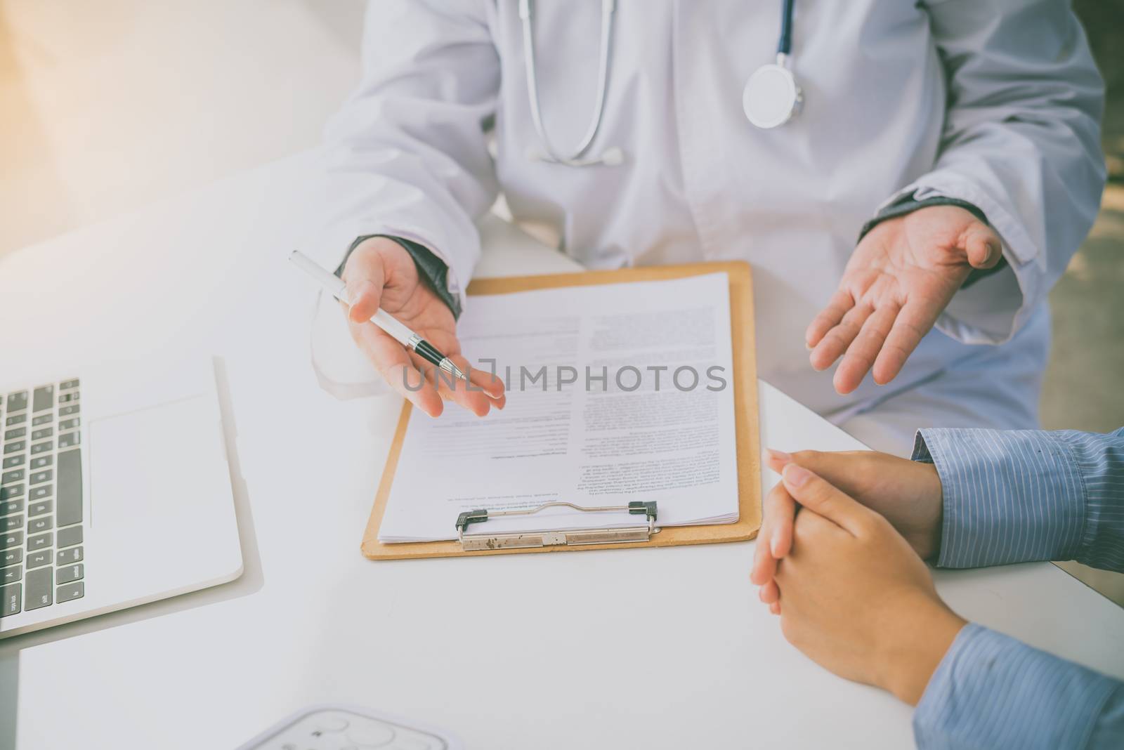 The doctor is discussing with the patient after a physical exami by photobyphotoboy