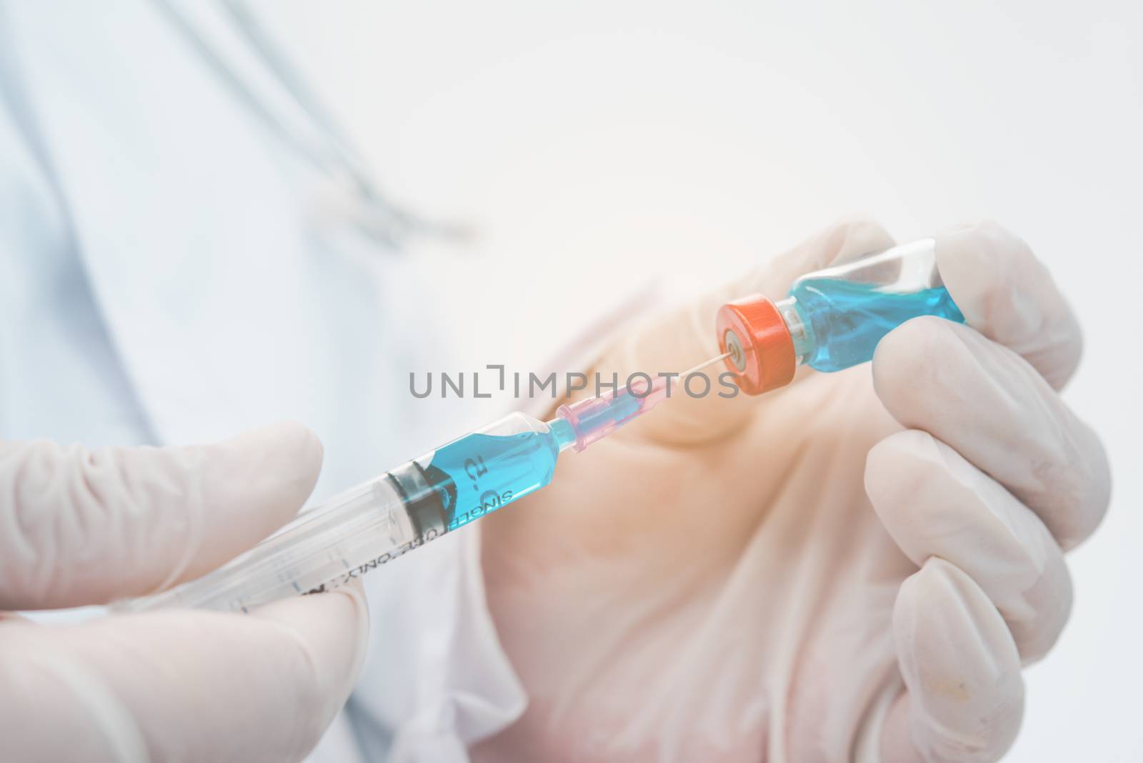 Doctor with syringe ready for injection of vaccine to patient. V by photobyphotoboy