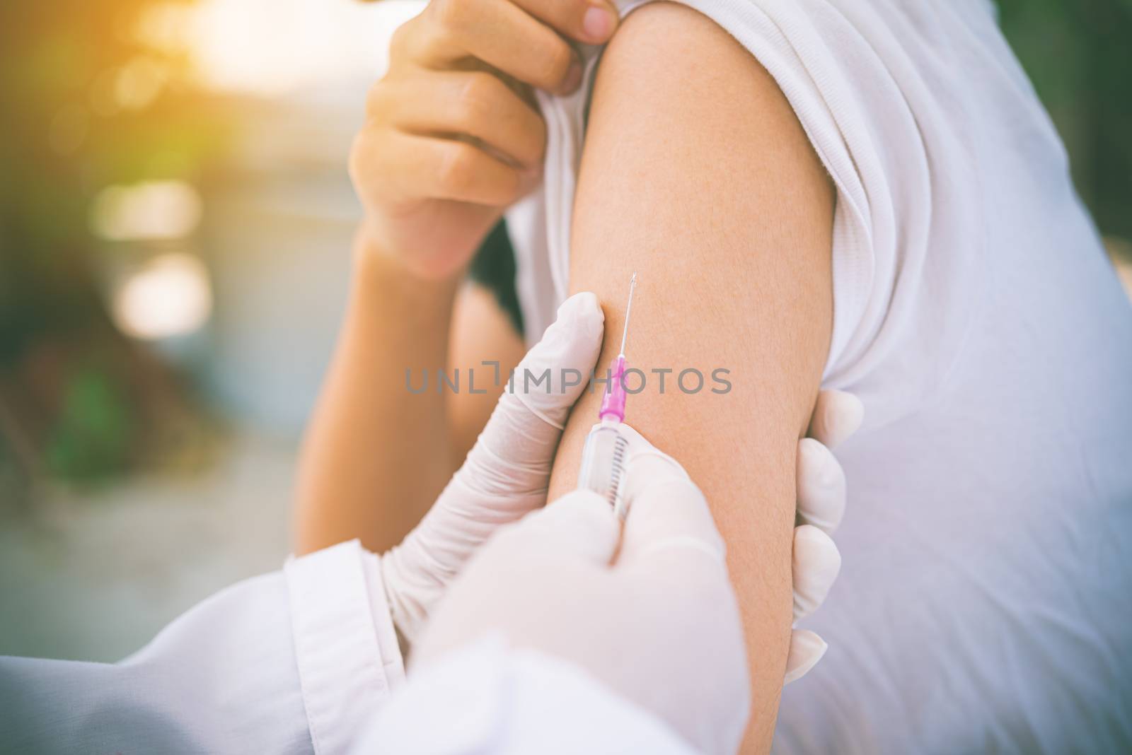 The doctor is currently treating patients by injecting arms. Vaccination or medication to prevent and treat viruses.