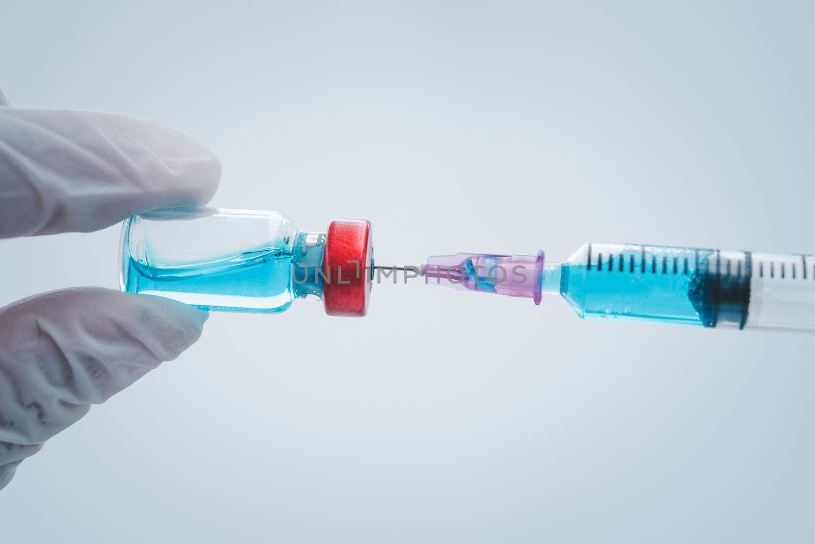 close-up doctor with syringe ready for injection of vaccine to p by photobyphotoboy