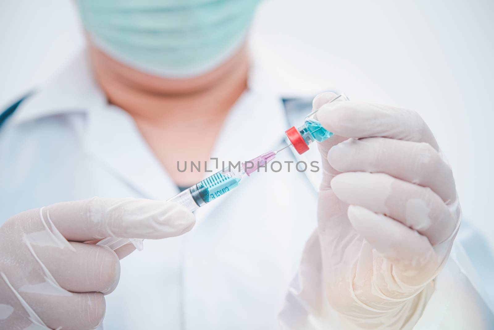 Doctor with syringe ready for injection of vaccine to patient. V by photobyphotoboy