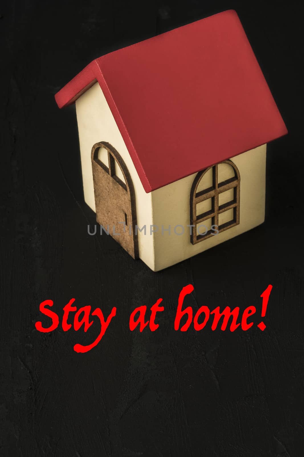 Stay at home template for coronavirus with a wooden house on black with copy space